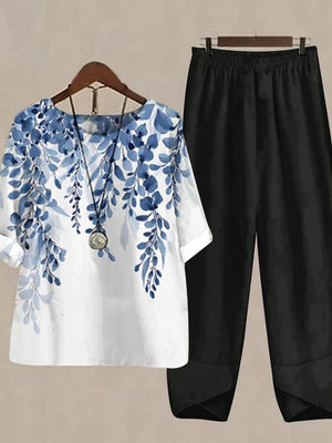 Floral print half sleeve top set in white with blue floral design and black pants.