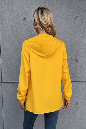 Gold hooded rain coat with long sleeves and elastic cuffs, shown from the back.