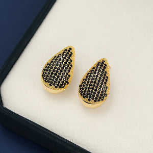 Pave teardrop studs with gold base and black stones.