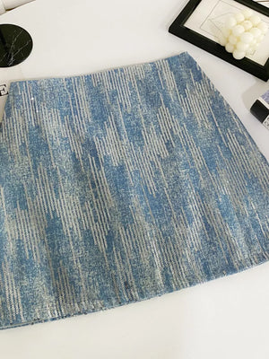 Light blue sequin mini skirt with a distressed denim look and vertical sequin stripes.