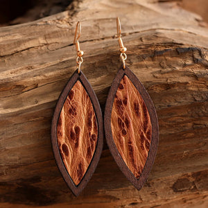 Tooled leather and wood drop earrings with a marquise shape and natural texture.