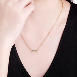 Gold bar necklace with three moissanite stones on a delicate chain.
