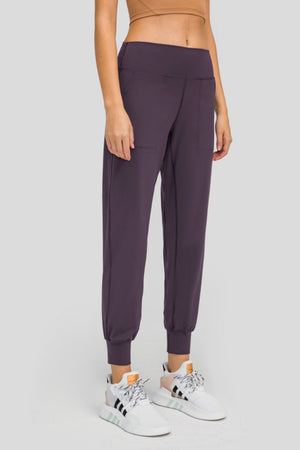 Plum purple jogger fit performance trousers with pockets and cuffed ankles.