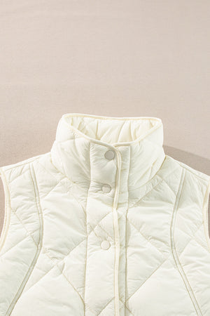 Ivory quilted stand collar vest with snap front closure and diamond pattern.