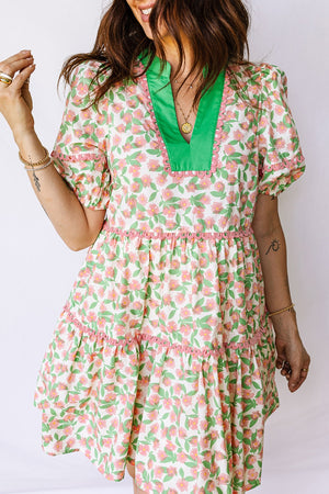 Women's tiered mini dress with green V-neck, pink trim, and floral print