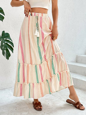 Chevron stripe tiered maxi skirt with drawstring waist and tassel detail.