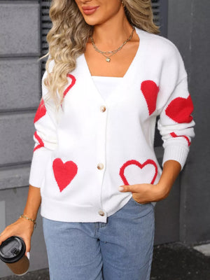 White knit cardigan with red heart pattern, button front, V-neck, long sleeves.