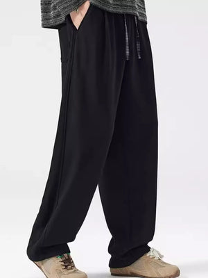 Black loose-fit men's casual sweatpants with drawstring waist and pockets.
