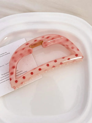 Polka dot claw hair clip in Style A, a translucent pink with red dots.