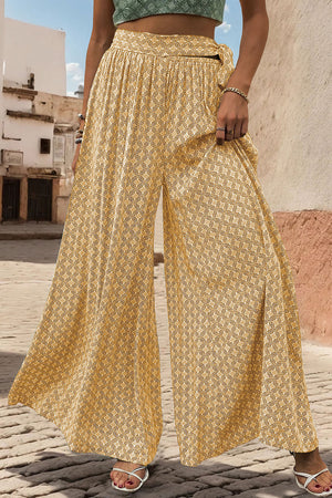 Yellow geometric print wide-leg palazzo trousers with a tie waist and side slits.