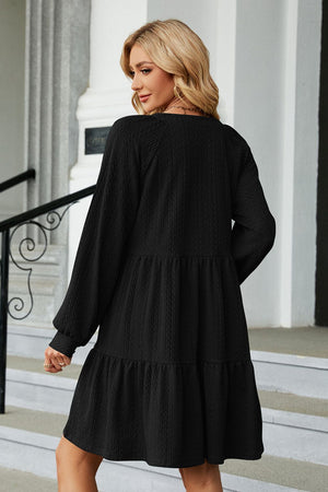 Black textured babydoll mini dress with voluminous sleeves and tiered skirt