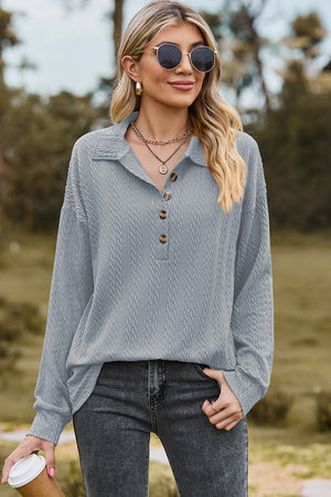 Light blue textured polo-neck sweater with button detail and long sleeves.
