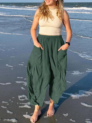 Dark green linen balloon trousers with cargo pockets and elastic waist