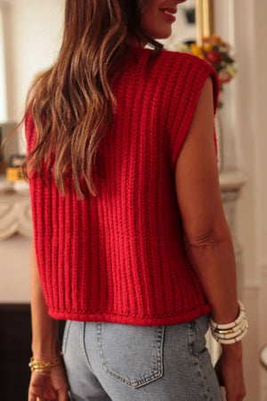 Chunky knit vest in deep red acrylic with ribbed texture and statement buttons, styled casually.