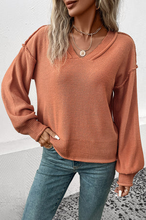 Raglan sleeve knit sweater in pumpkin acrylic with raw edge details and v-neck.