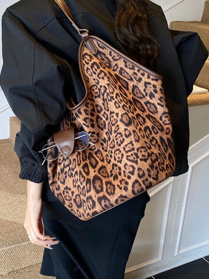 Chic leopard print tote bag with brown trim and a glasses holder detail.