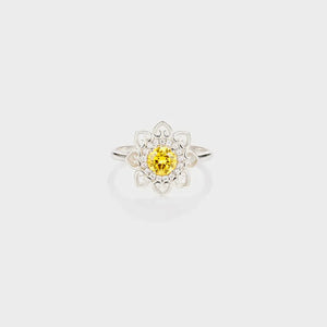 Silver ring with yellow center stone and floral filigree design.