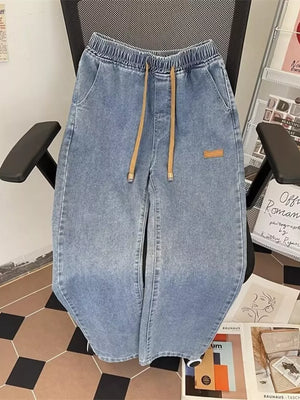 Light blue wide-leg jeans with drawstring waist and side pockets.