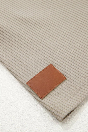 Ribbed knit mini dress in beige with a brown faux leather patch detail.