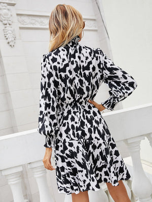 Abstract print midi dress with shirred waist and ruffled cuffs.