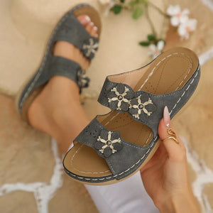 Gray floral appliqué mid-heel sandals with double straps and perforated details.
