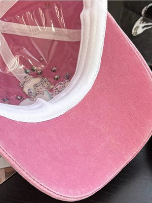Pink cotton baseball cap with embroidered detail and clear plastic lining.