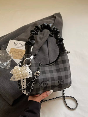 Black plaid mini crossbody bag with ruched handle and pearl charm.