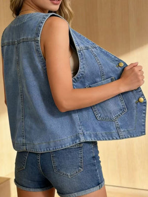 Light blue denim button-down vest with brass buttons and chest pockets.