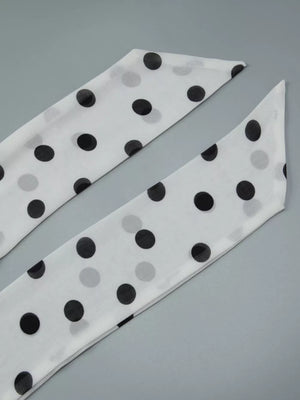 White polka dot scarf with black dots, a chic accessory.