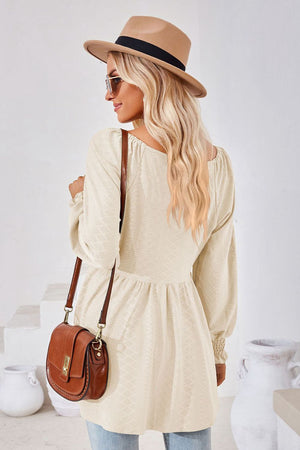 Cream textured babydoll blouse with smocked cuffs and square neckline.