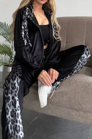 Black velvet tracksuit with leopard print panels on jacket and pants.