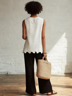 White sleeveless tank top with scalloped hem detail and keyhole back.