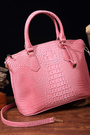 Pink crocodile embossed satchel bag with top handles and shoulder strap.