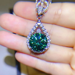 Emerald moissanite halo pendant necklace in silver with a teardrop shape and sparkling white stones.