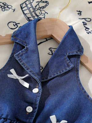 Dark blue denim sleeveless baby dress with white bowknot details and buttons.
