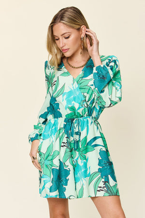 Green floral wrap romper with V-neck, long sleeves, and drawstring waist