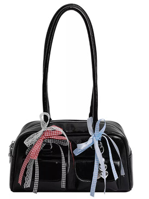 Black patent shoulder bag with ribbon and lace embellishments and heart charms.