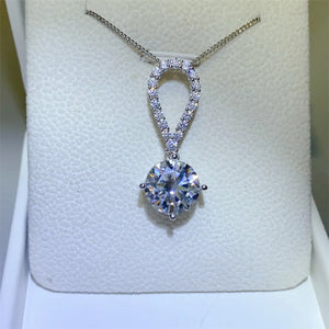 Silver pavé halo solitaire pendant necklace with a large round-cut diamond.