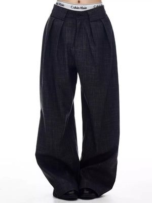 Men's dark grey wide-leg trousers with pleats and a textured fabric.