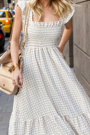 Smocked gingham maxi dress with square neckline and flutter sleeves.