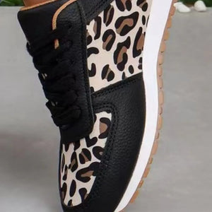 Black leather sneakers with leopard print panels and black laces.