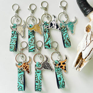 Embossed leather bull keychains with crystal accents in various animal prints and colors.