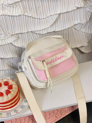 Playful mini crossbody bag in cream with pink accents and cat ears.