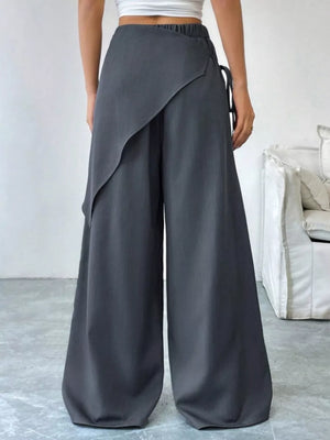 Chic dark gray maternity wide-leg pants with a high waist and wrap-style overlay.