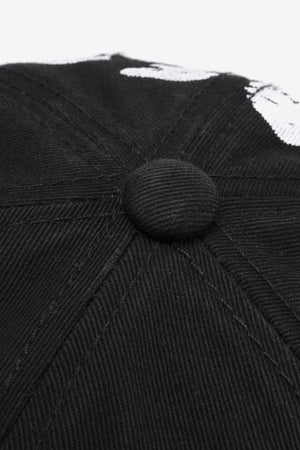 Black baseball cap with white graffiti detail and button top.
