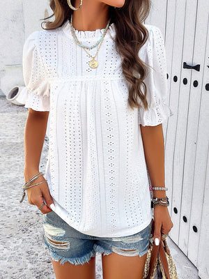 White eyelet blouse with ruffled puff sleeves and mock neck.