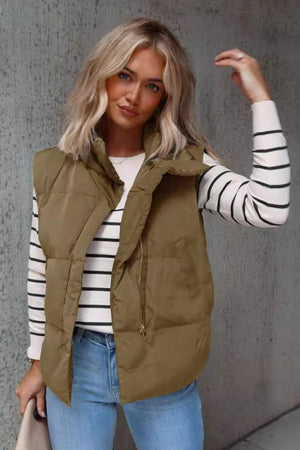 Padded stand collar vest in olive brown with a zip front, worn over a striped long-sleeve shirt.