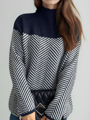 Chevron knit turtleneck sweater with colorblock pattern in dark blue and white.