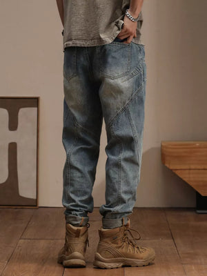 Relaxed fit vintage wash denim jeans with paneling detail, cuffed ankles.