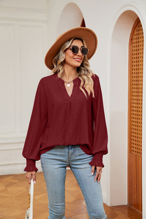 Wine eyelet detail poet sleeve blouse with V-neck and ruffled cuffs.